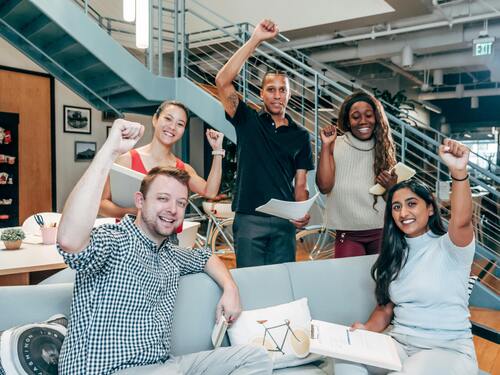 Équipe d’experts en stratégie digitale à Lille Groupe de professionnels souriants levant le poing, représentant l’équipe dynamique de Pyramids Digital, votre agence web à Lille, spécialisée en création de sites internet et en stratégie SEO.